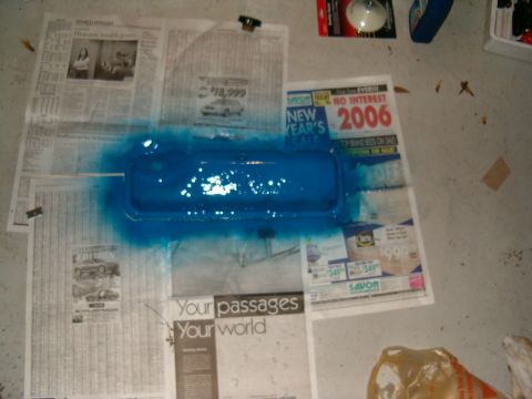 1979 Ford Bronco - A blue painted car part is drying on top of newspapers, one of which advertises a 2006 New Year's sale.