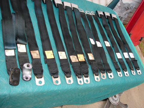 1973 Ford Ranchero - Collection of black seat belts with metal buckles and mounting hardware visible.