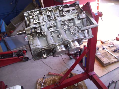 1995 Ford Probe - A disassembled engine block is mounted on a red engine stand in a workshop.