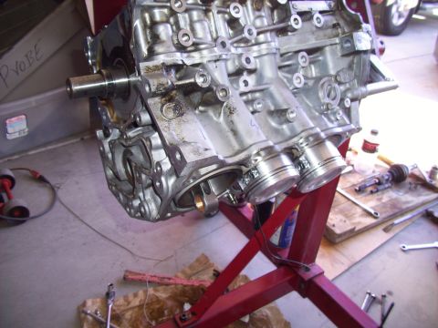 1995 Ford Probe - Engine block with pistons on a stand, with tools and a bottle nearby.