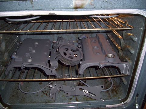 1995 Ford Probe - Car engine components are placed inside an oven, likely for curing paint or sealant.