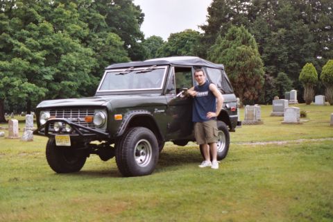 1976 Ford Bronco - Man poses with a 1976 Ford Bronco in a cemetery setting.