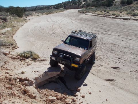 1986 Ford Bronco II - 1986 Ford Bronco II tackling rough terrain on a sunny day.