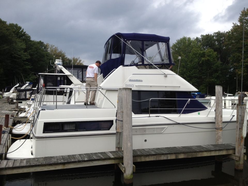 White aft cabin boat with blue canvas, side view. Registry: 1985 Carver 326 Aft Cabin