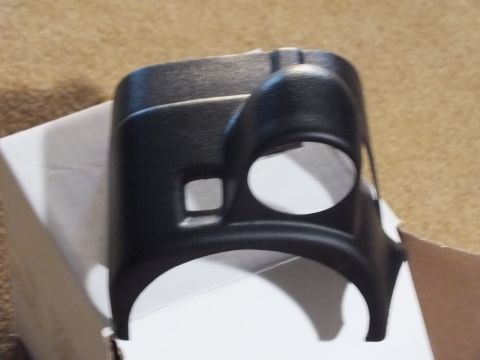 2003 Ford Crown Victoria - close-up of a black textured plastic steering-column gauge pod showing two round gauge openings and a small square cutout.