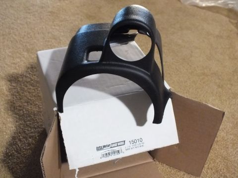 2003 Ford Crown Victoria - black plastic steering-column gauge pod resting on a cardboard box labeled with an Auto Meter Gauge Works barcode and part number 15010.