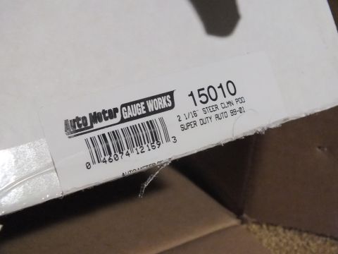 2003 Ford Crown Victoria - Close-up of an Auto Meter Gauge Works box label, part number 15010, for a 2 1/16-inch steering-column pod, Super Duty Auto 99-01.