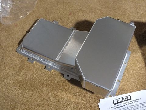 2003 Ford Crown Victoria - Top-down view of a fabricated aluminum oil pan with welded baffle structure and mounting flange, beside a Moroso instruction sheet.