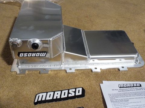 2003 Ford Crown Victoria - Fabricated aluminum Moroso oil pan with a stepped sump and side fittings, shown beside a printed instruction sheet and decal.