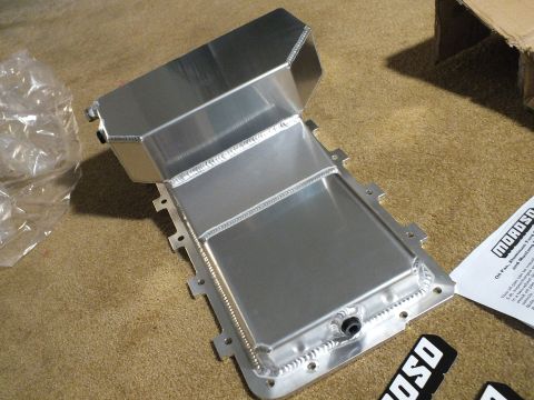 2003 Ford Crown Victoria - Top-down view into a fabricated aluminum oil pan revealing internal baffling and a threaded drain bung, with a Moroso decal nearby.