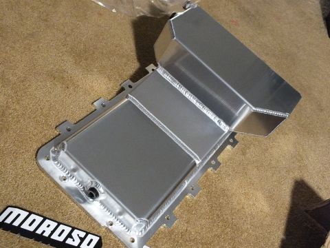 2003 Ford Crown Victoria - Top view of a fabricated aluminum oil pan with stepped sump and internal baffling, a Moroso decal lying in the foreground.