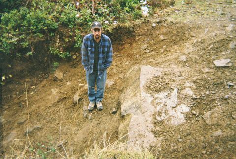 1983 Ford Bronco - A man in a blue plaid flannel shirt, jeans and ball cap stands on a rock ledge at the bottom of an eroded dirt bank, apparently for scale o…