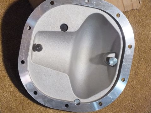 2003 Ford Crown Victoria - Interior of a cast aluminum differential cover showing the rough-cast cavity, machined sealing flange, and perimeter bolt holes.