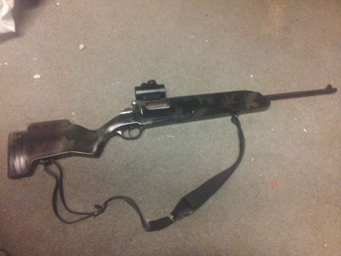 1986 Ford Bronco - Rifle with scope and sling on carpet.