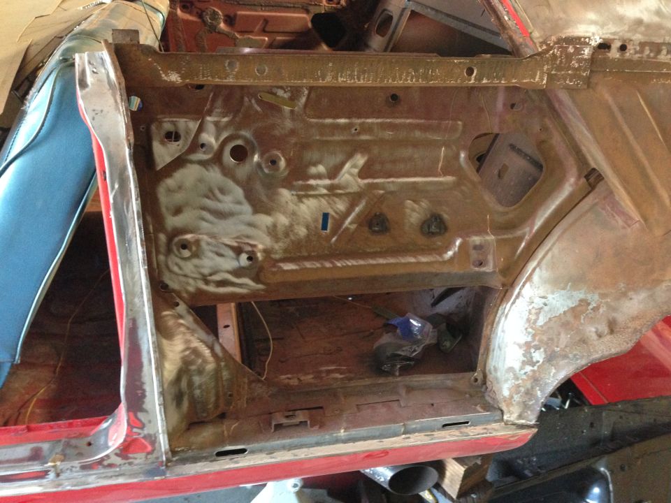 Interior of a car door frame, showing rust and bare metal