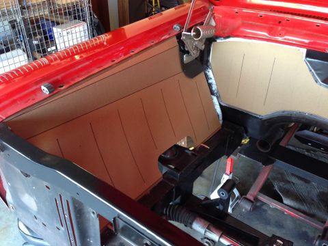 1964 Ford Fairlane - A cardboard template is being fitted to the firewall of a red car's interior.