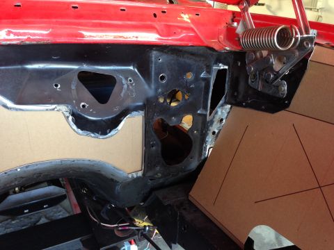 1964 Ford Fairlane - Cardboard templates are placed on the firewall of a red car's engine bay during restoration.