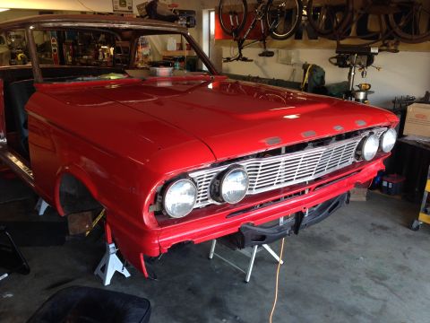 1964 Ford Fairlane - Front view of a red 1964 Ford Fairlane in a garage, with the front end raised on jack stands.