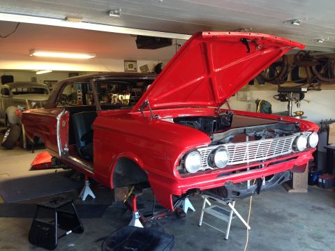 1964 Ford Fairlane - 1964 Ford Fairlane in garage, hood up, being worked on. Front grille and headlights visible.