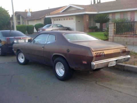 1968 Ford Mustang - This brown 1973 Dodge Dart is seen from the rear, a chrome bumper and distinctive slotted taillights.