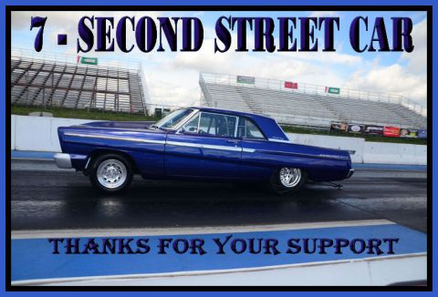 1965 Ford Fairlane - A blue 1965 Ford Fairlane coupe is shown on a drag strip with grandstands in the background.