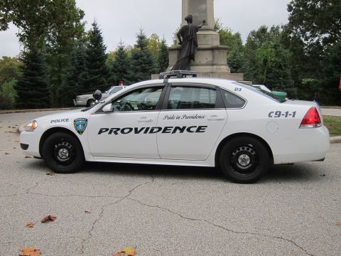 2001 Ford Crown Victoria - Side view of a Providence police car parked outdoors with a monument in the background.