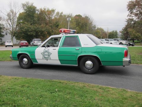 2001 Ford Crown Victoria - This Sheriff car is painted green and white and has a light bar on its roof.