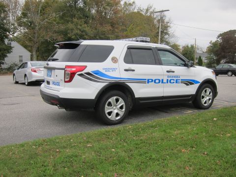 2001 Ford Crown Victoria - Police SUV with "EMERGENCY DIAL 911" and "SWANSEA POLICE" text is parked near other vehicles.