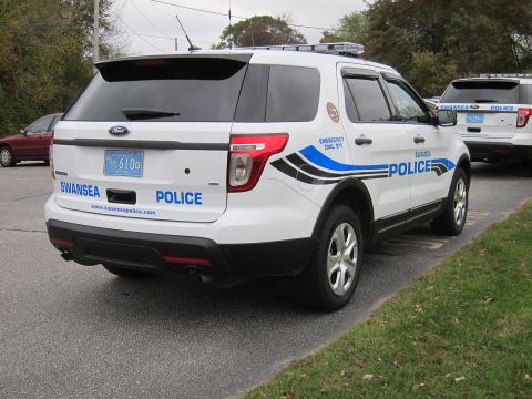 2001 Ford Crown Victoria - A white police SUV with 'SWANSEA POLICE' markings is parked behind another similar vehicle.
