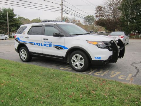 2001 Ford Crown Victoria - White police SUV marked 'SWANSEA POLICE' with unit number 140 visible.
