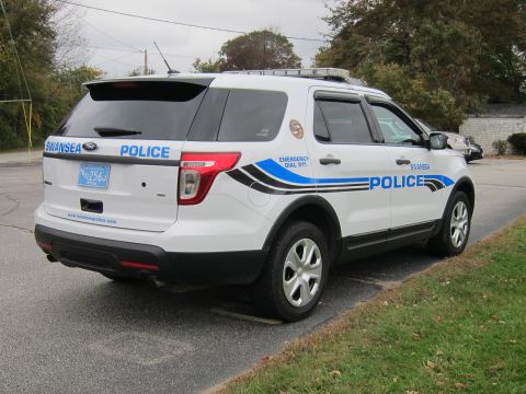 2001 Ford Crown Victoria - A white police SUV with 'SWANSEA POLICE' markings is viewed from the rear quarter.