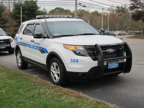 2001 Ford Crown Victoria - A police SUV, marked "SWANSEA POLICE", is parked on the side of the road with another police vehicle behind it.