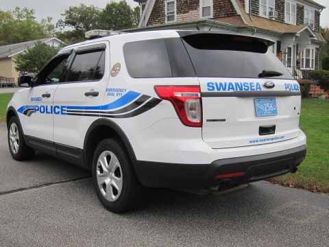2001 Ford Crown Victoria - A white police SUV with 'SWANSEA POLICE' markings is shown from the rear, parked in front of a residential building.