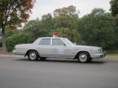 2001 Ford Crown Victoria - A gray police car with 'Rhode Island State Police' text on the side is parked on a paved surface.