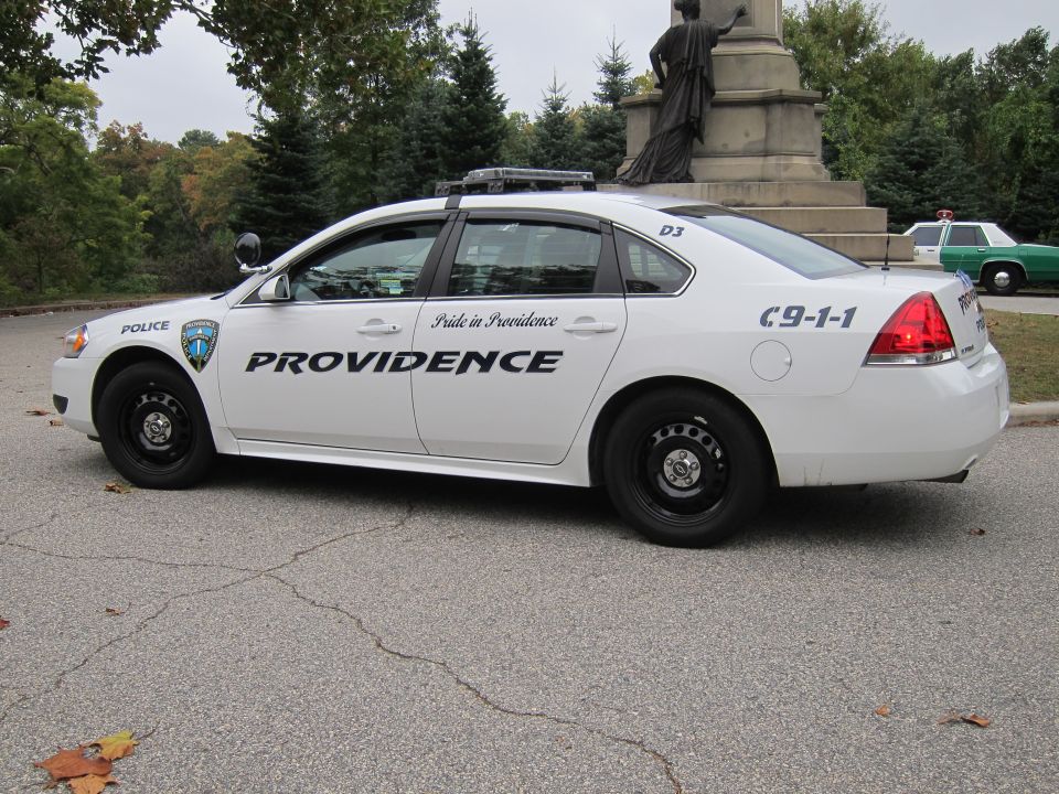 White police sedan with "PROVIDENCE" text, parked on asphalt
