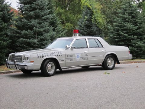 2001 Ford Crown Victoria - This police car has 'STATE POLICE' and 'RHODE ISLAND POLICE' text on its side.