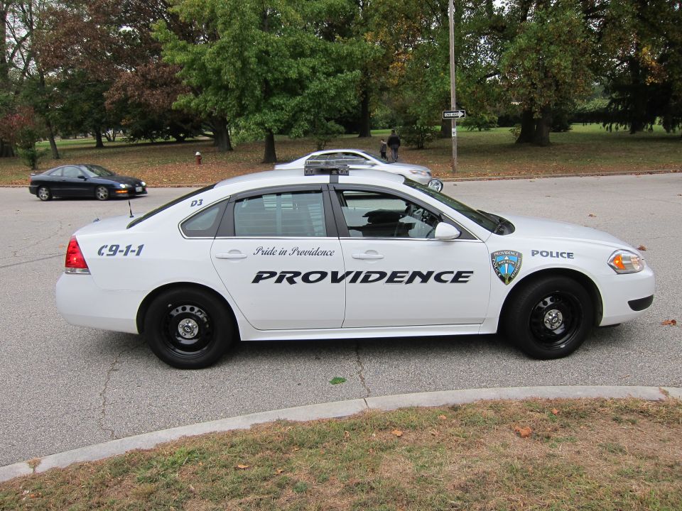 Side view of white police car with Providence markings and C-9-1-1 on rear door