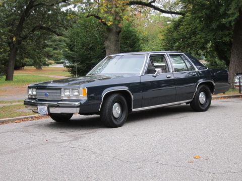 2001 Ford Crown Victoria - This 2001 Ford Crown Victoria is seen from a 3/4 front angle on a tree-lined street.