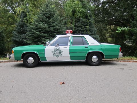 2001 Ford Crown Victoria - Photograph of a classic green-and-white Sheriff sedan, not a technical document.