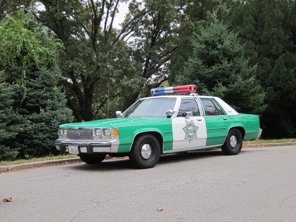 Green-and-white Sheriff Ford LTD Crown Victoria police sedan, front view