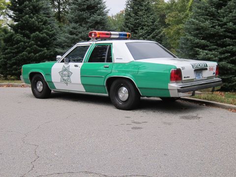 2001 Ford Crown Victoria - Photograph of a green-and-white sheriff Ford Crown Victoria police car, not a technical document.