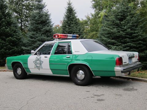2001 Ford Crown Victoria - Photograph of a green-and-white sheriff Ford Crown Victoria police car, not a technical document.