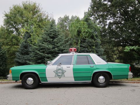 2001 Ford Crown Victoria - Photograph of a green and white Sheriff patrol sedan, not a technical document.