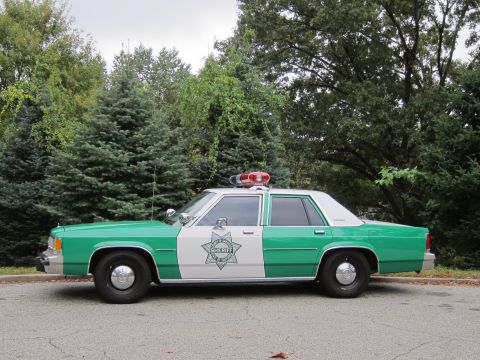 2001 Ford Crown Victoria - Photograph of a green and white Sheriff patrol sedan, not a technical document.