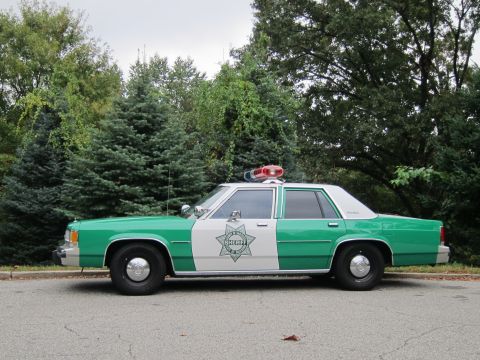 2001 Ford Crown Victoria - Photograph of a green and white Sheriff patrol sedan, not a technical document.