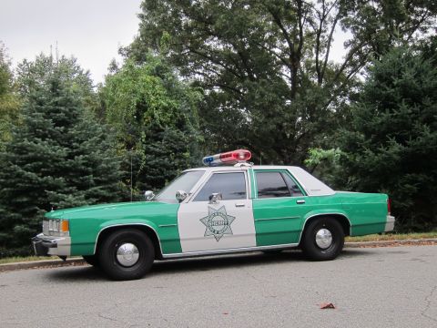 2001 Ford Crown Victoria - Photograph of a green and white Sheriff patrol sedan, not a technical document.
