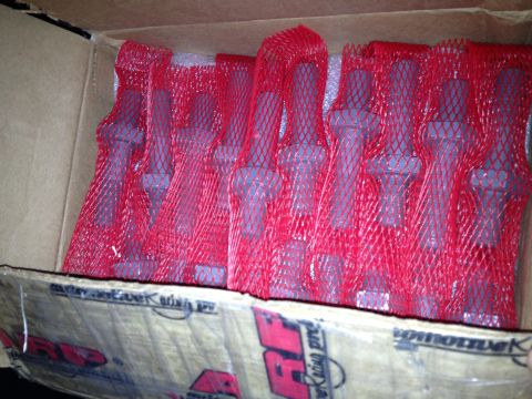 1998 Ford Crown Victoria - cardboard box filled with fasteners individually wrapped in red protective mesh, beside ARP racing-products packaging.