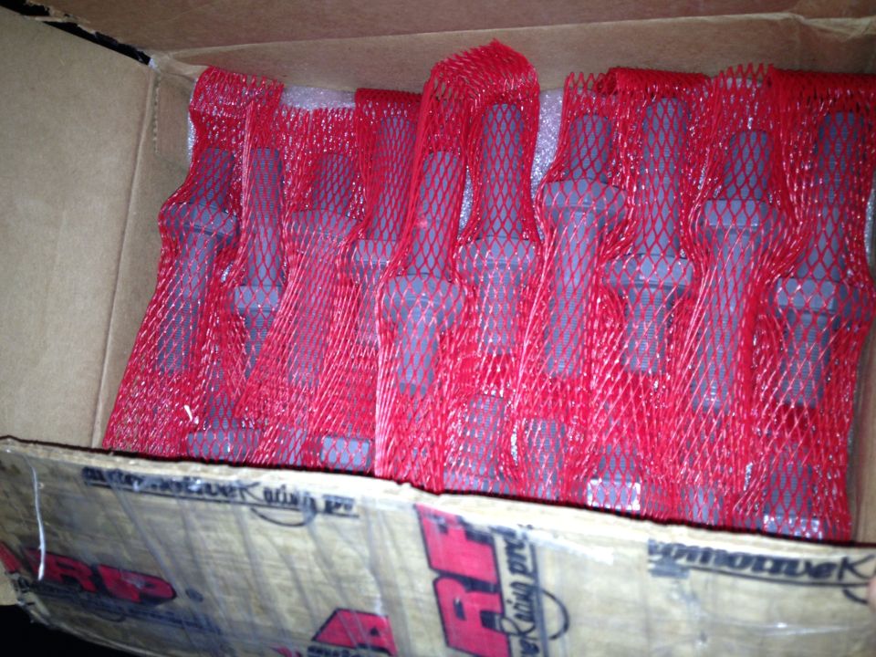 Cardboard box of red-mesh-wrapped fasteners with ARP branded packaging