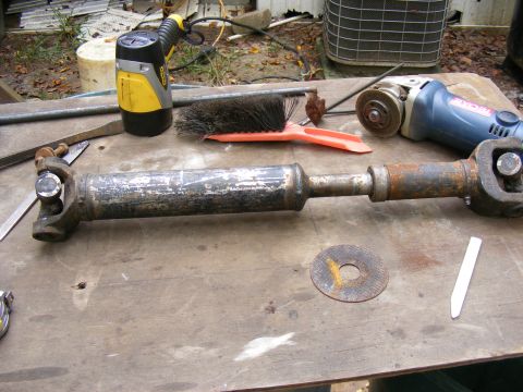 Driveshaft and tools on a wooden workbench
