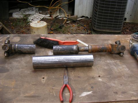Driveshaft parts on a wooden workbench.